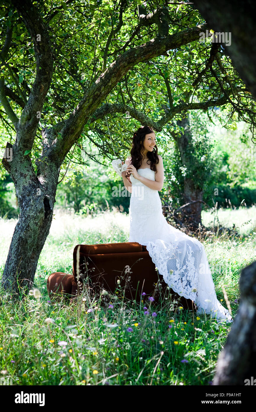 Bride in white wedding dress posing at the meadow Stock Photo - Alamy