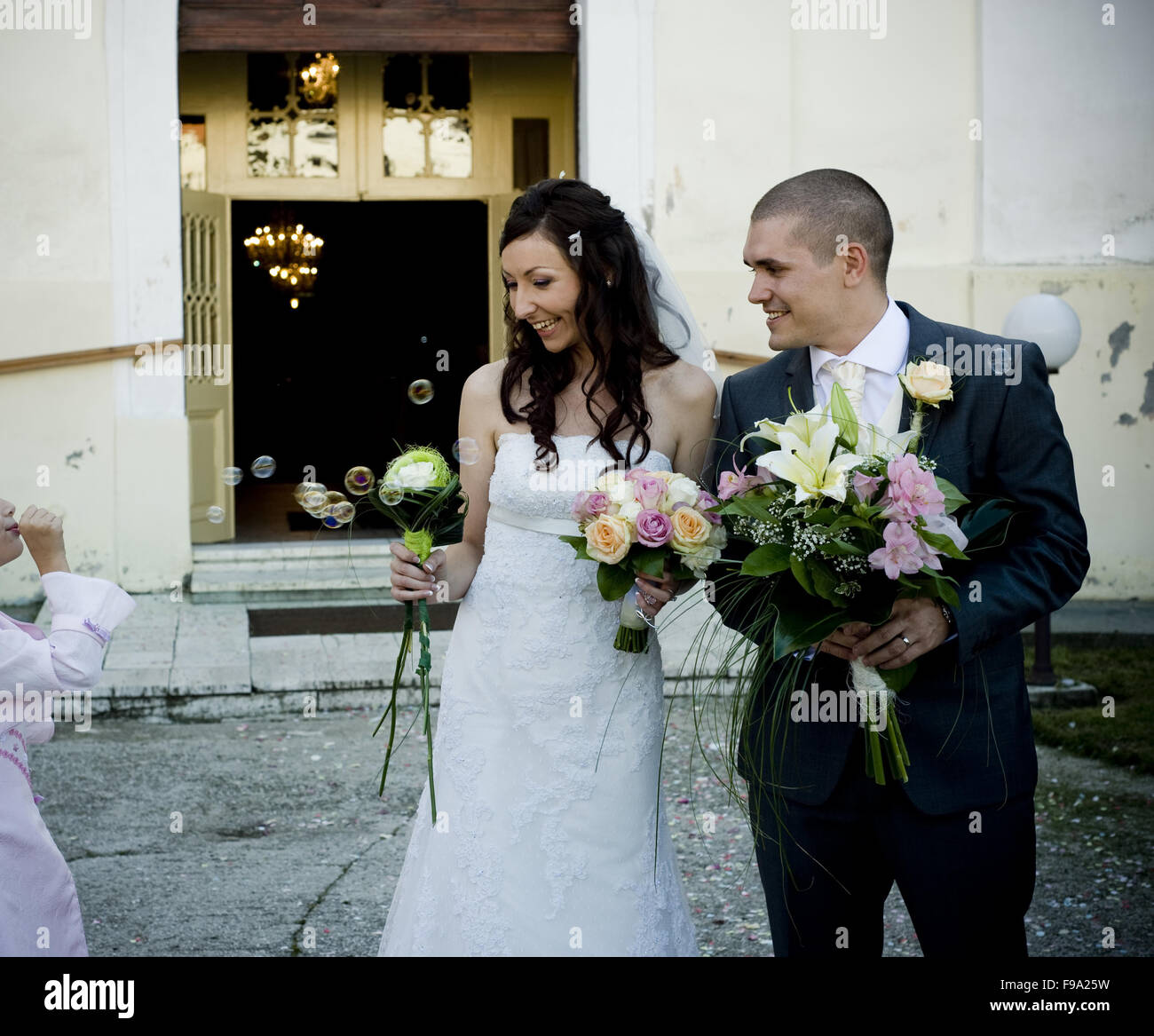 Bride and groom posing in front of the church Stock Photo - Alamy
