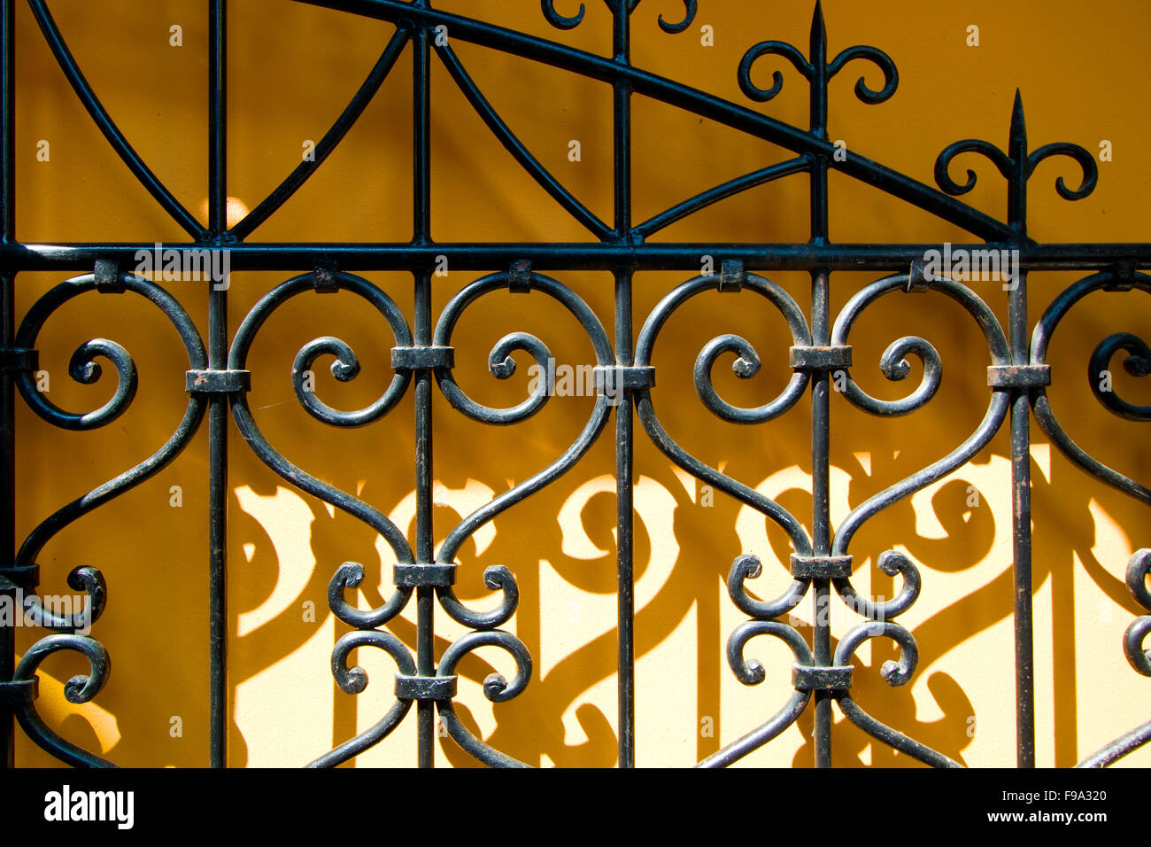 Yellow wall with a black gate Stock Photo