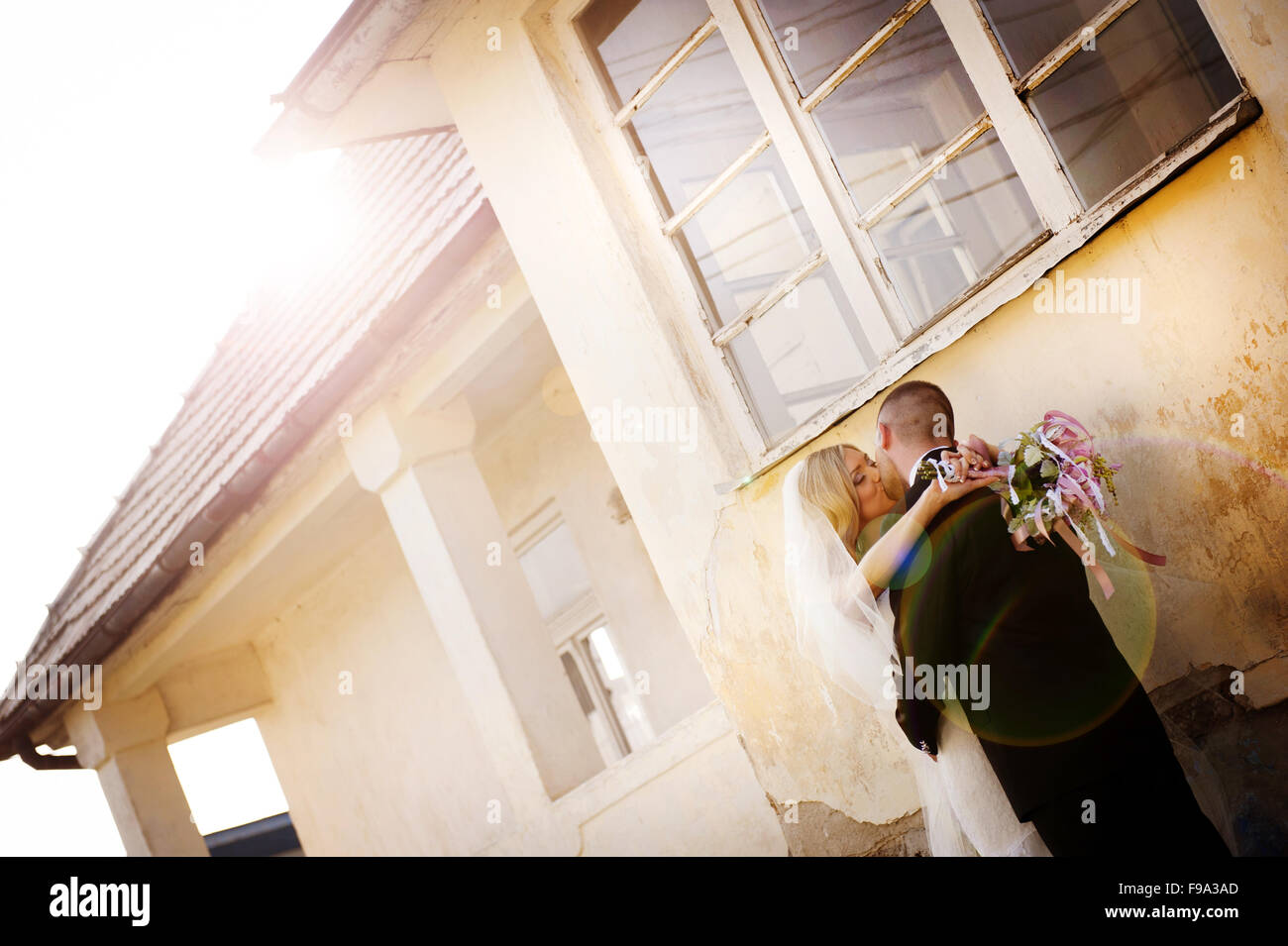Happy bride and groom posing by the old house Stock Photo - Alamy