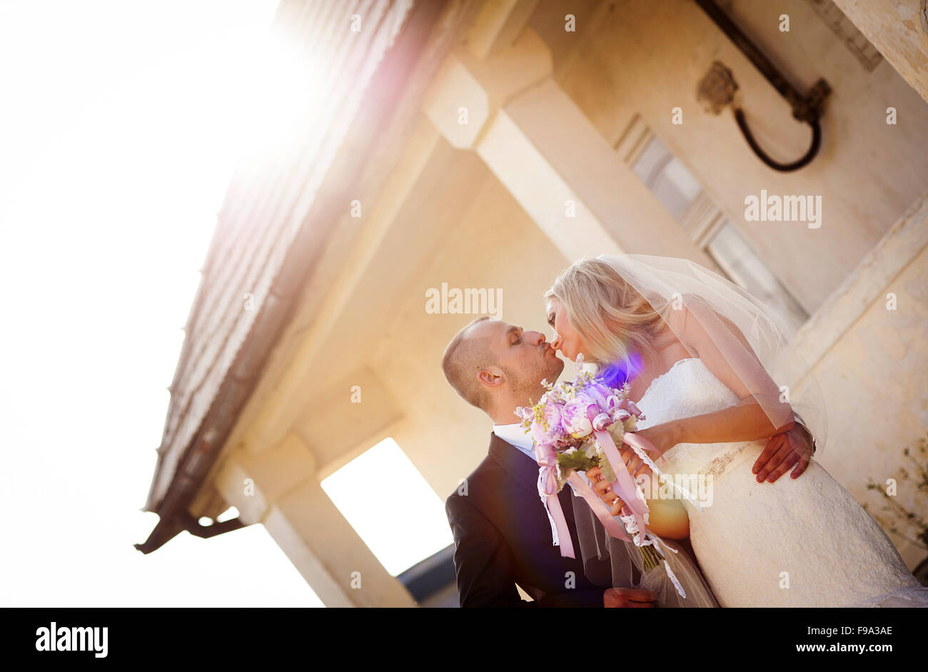 Happy bride and groom posing by the old house Stock Photo - Alamy