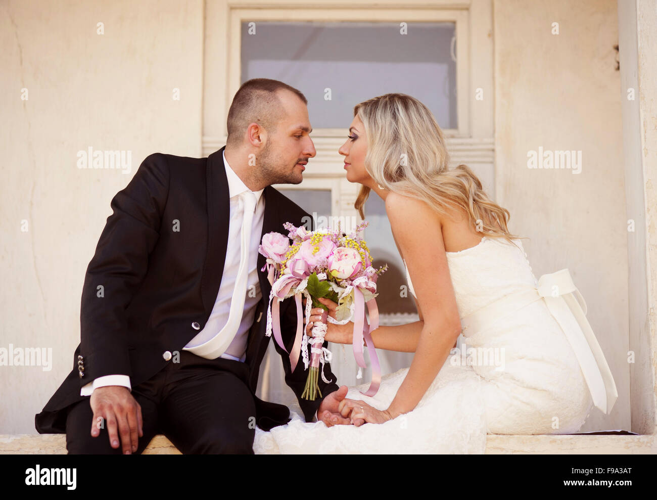 Happy bride and groom posing by the old house Stock Photo - Alamy