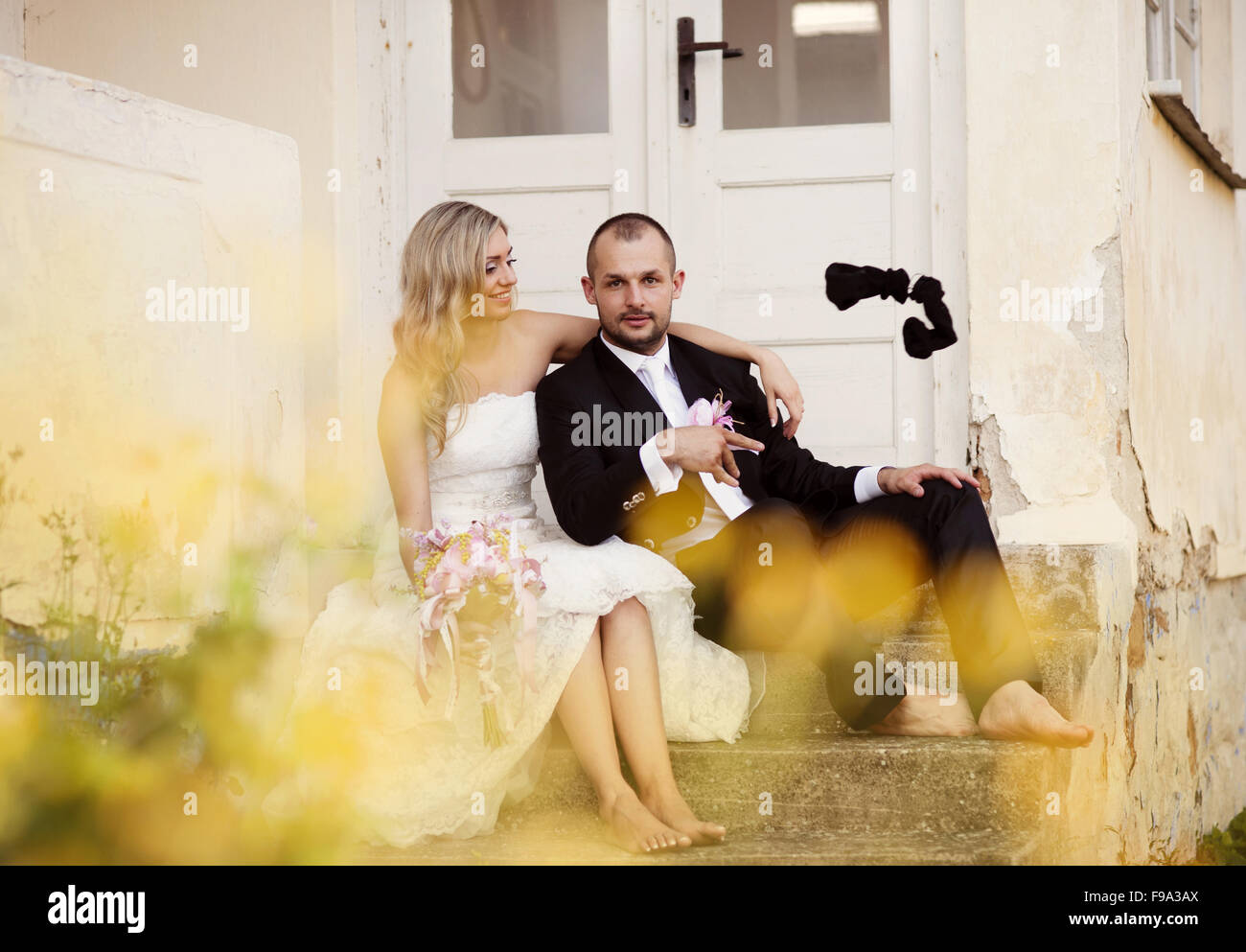 Happy bride and groom posing by the old house Stock Photo - Alamy