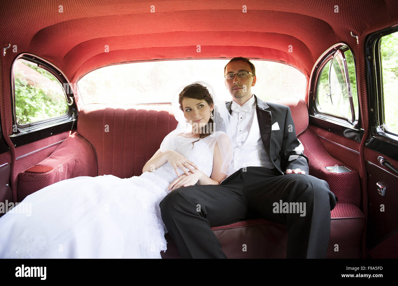 Bride and groom are sitting inside the retro car Stock Photo - Alamy