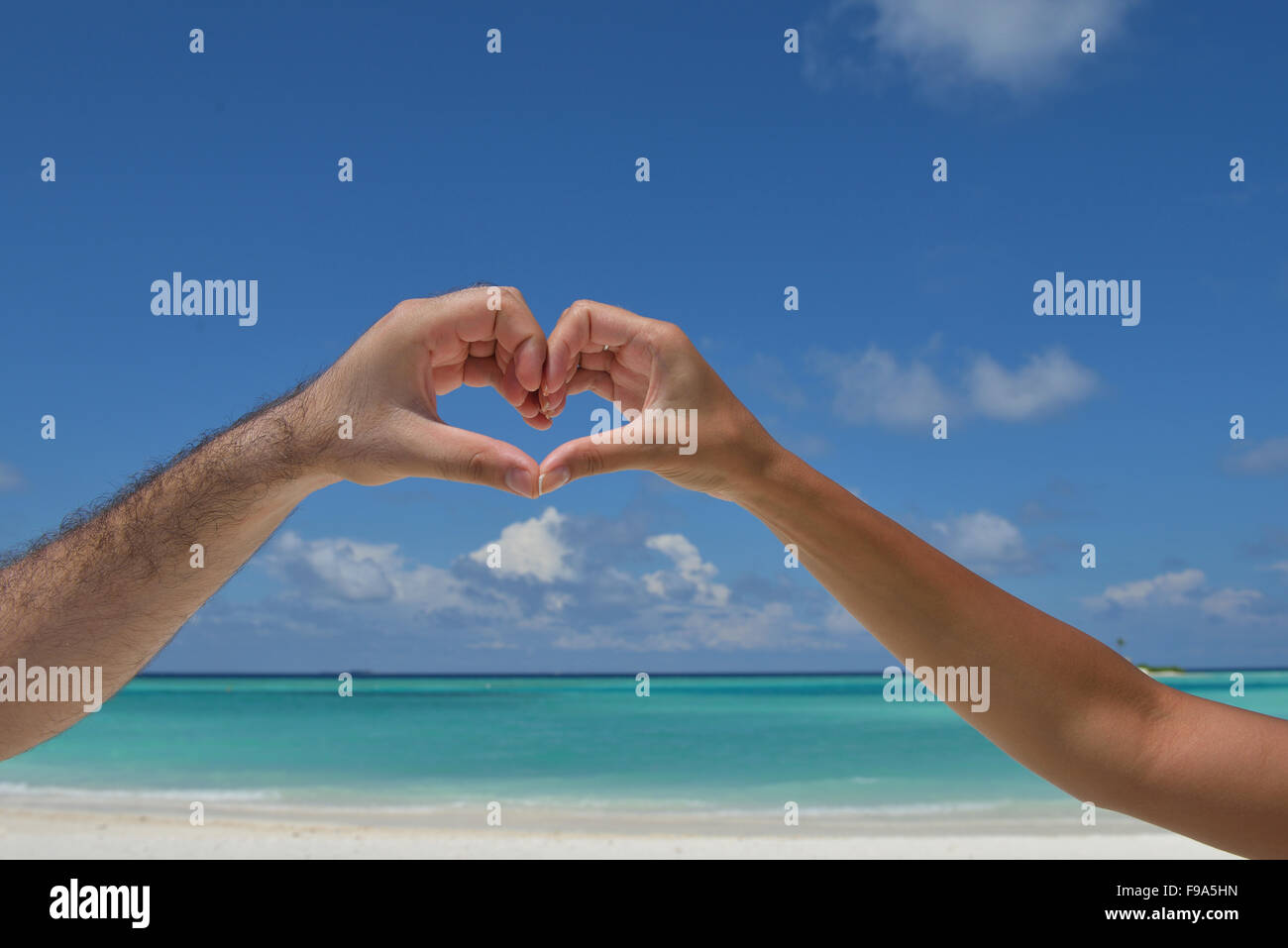 romantic couple make heart shape symbol of love with arms on sunny ...
