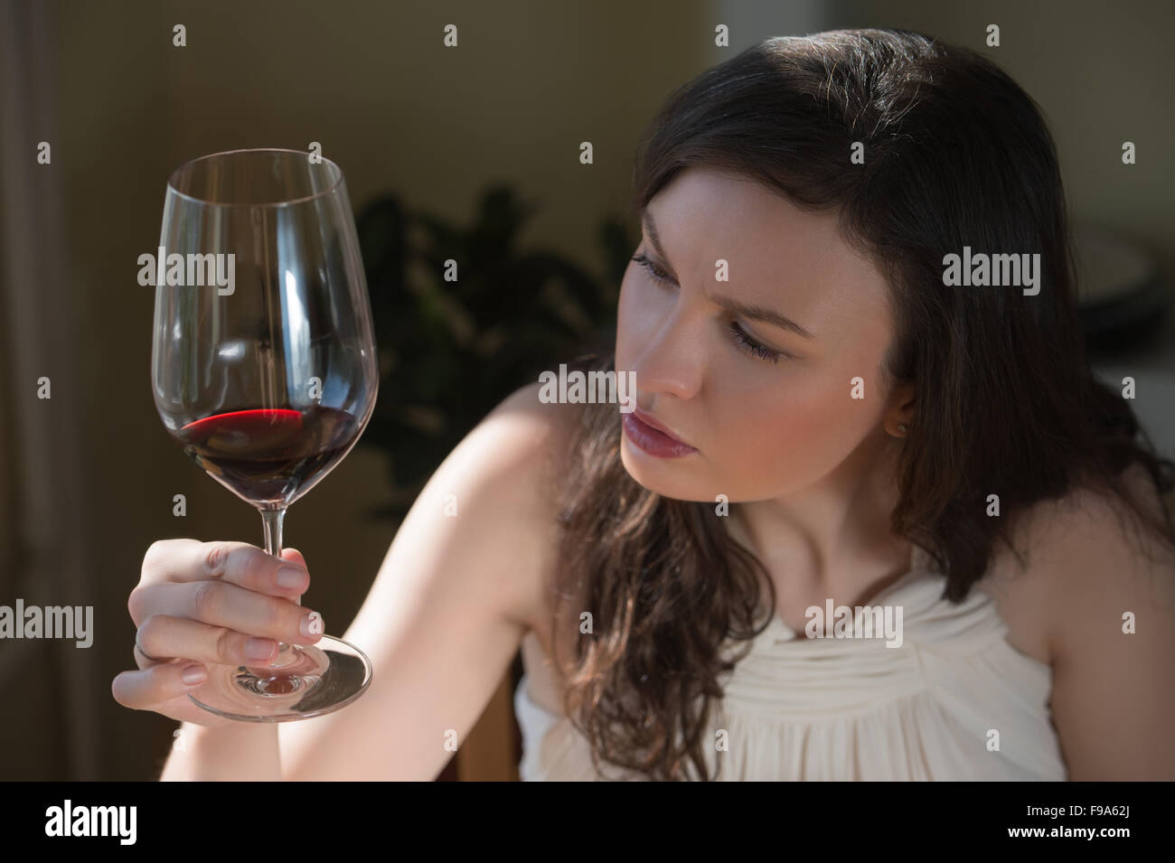 Closeup portrait of young woman drinking red wine at home Stock Photo