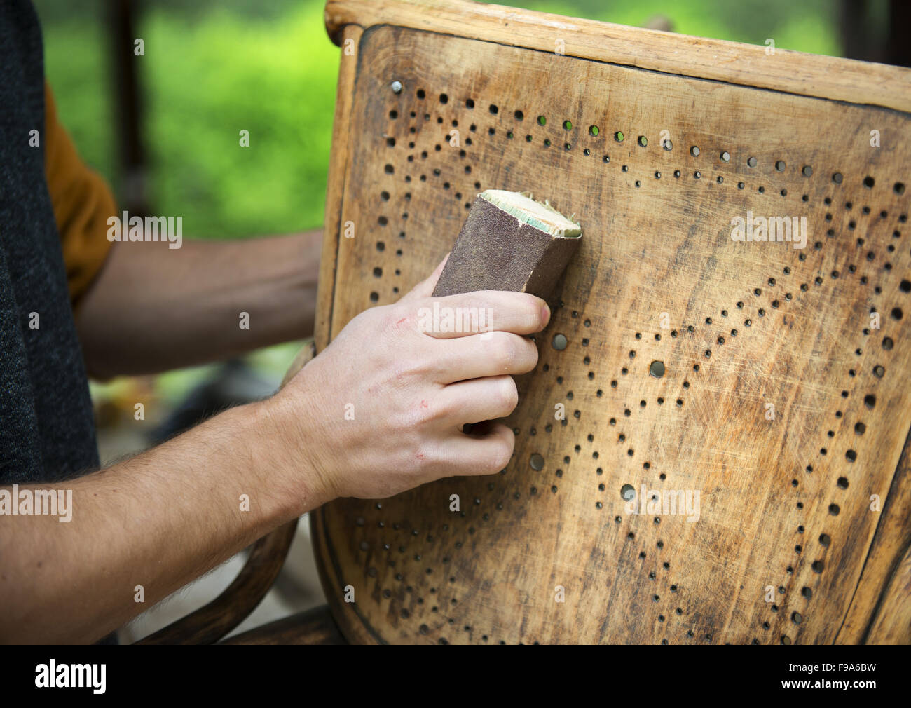 Restoration, removing paint from antique chair with sandpaper Stock