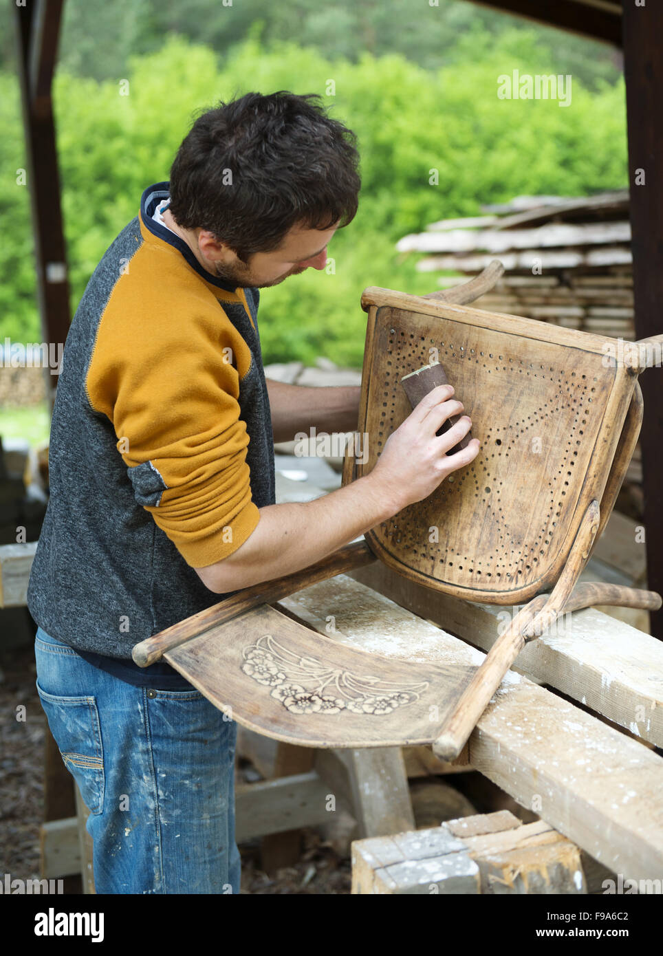 Restoration, removing paint from antique chair with sandpaper Stock