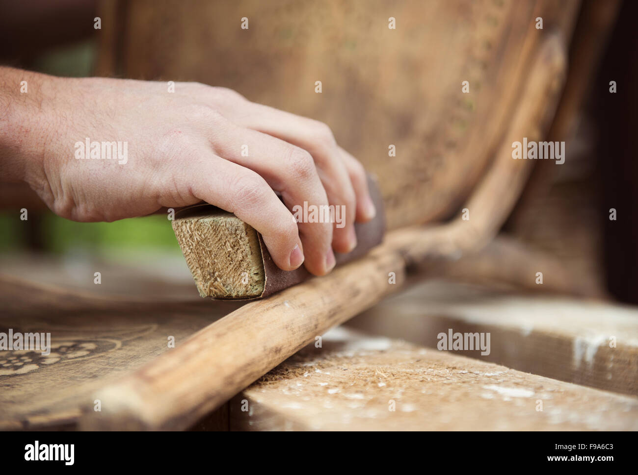 Restoration, removing paint from antique chair with sandpaper Stock