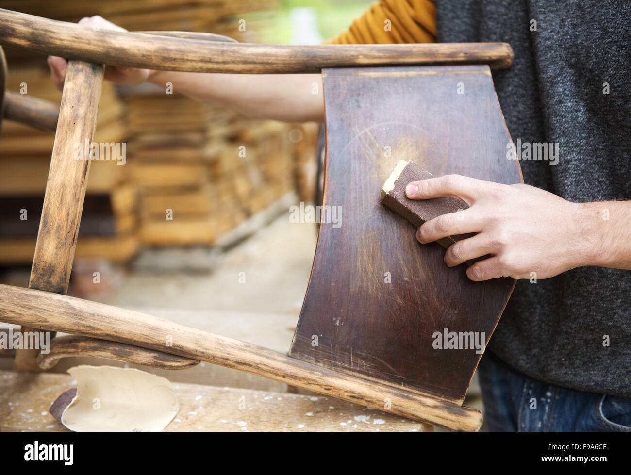 Restoration, removing paint from antique chair with sandpaper Stock