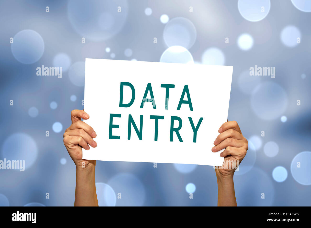 DATA ENTRY card in hand with abstract light background. Selective focus. Stock Photo