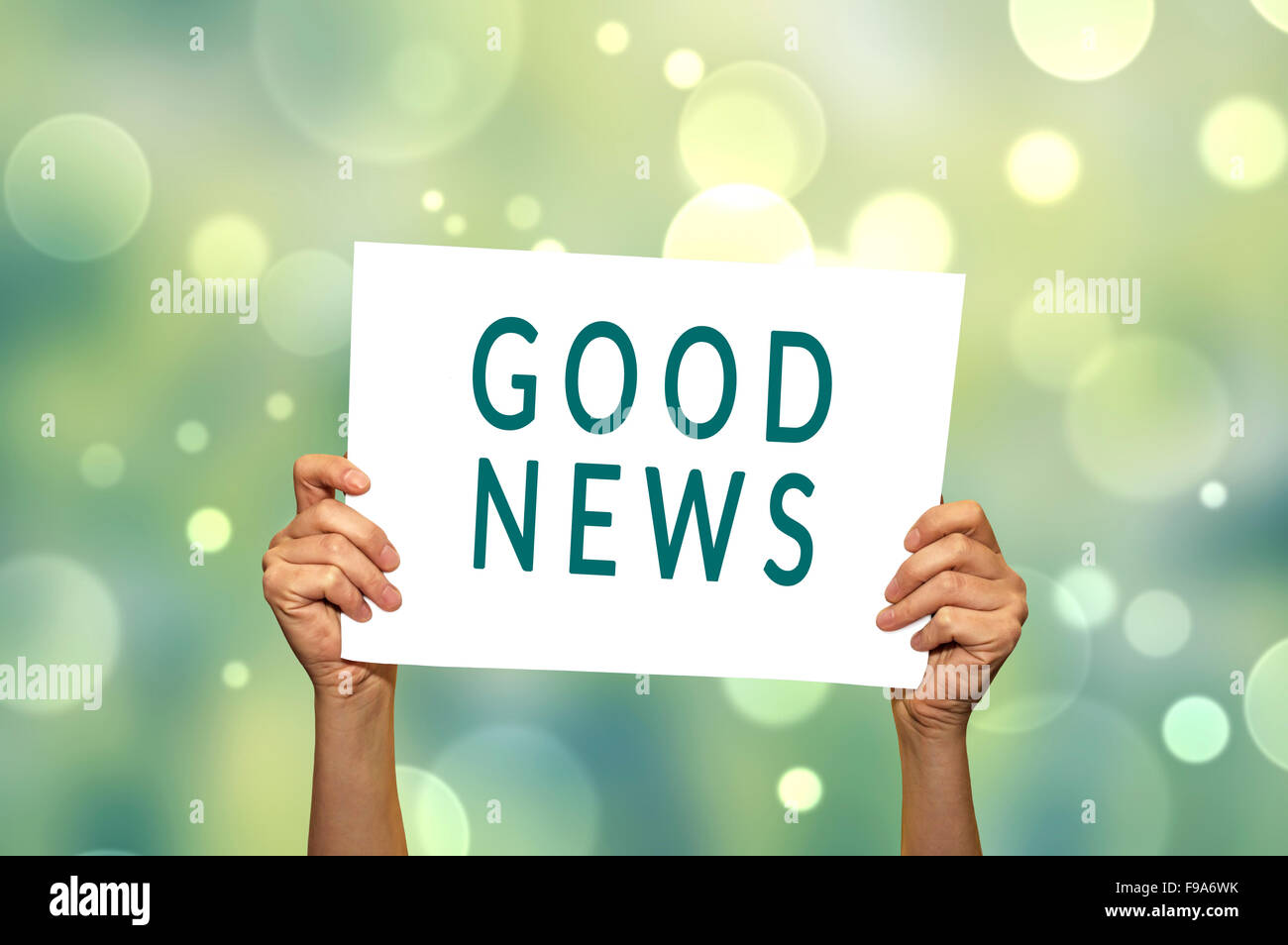 GOOD NEWS card in hand with abstract light background. Selective focus. Stock Photo