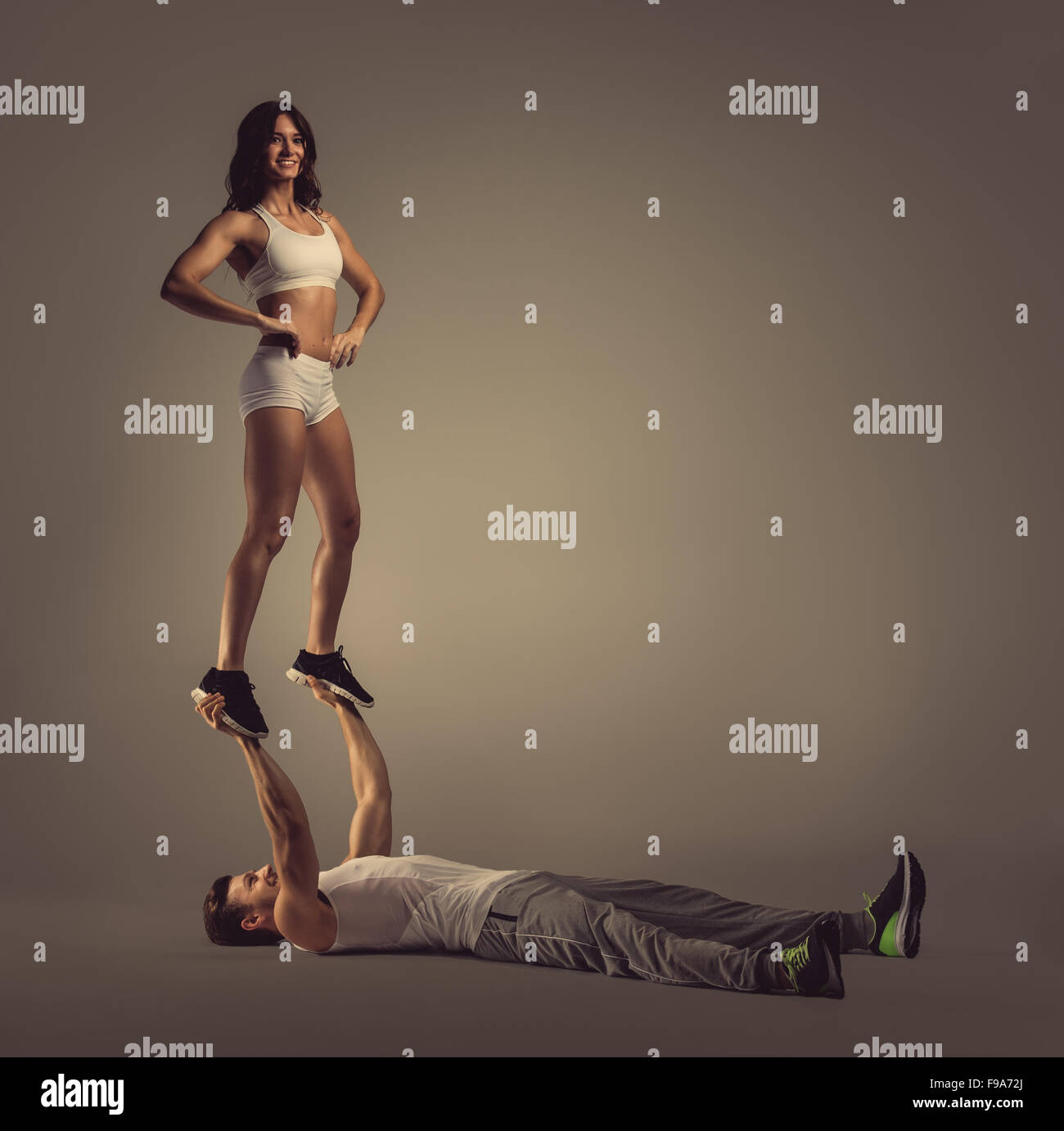 Athletic couple doing acro yoga, studio shot Stock Photo