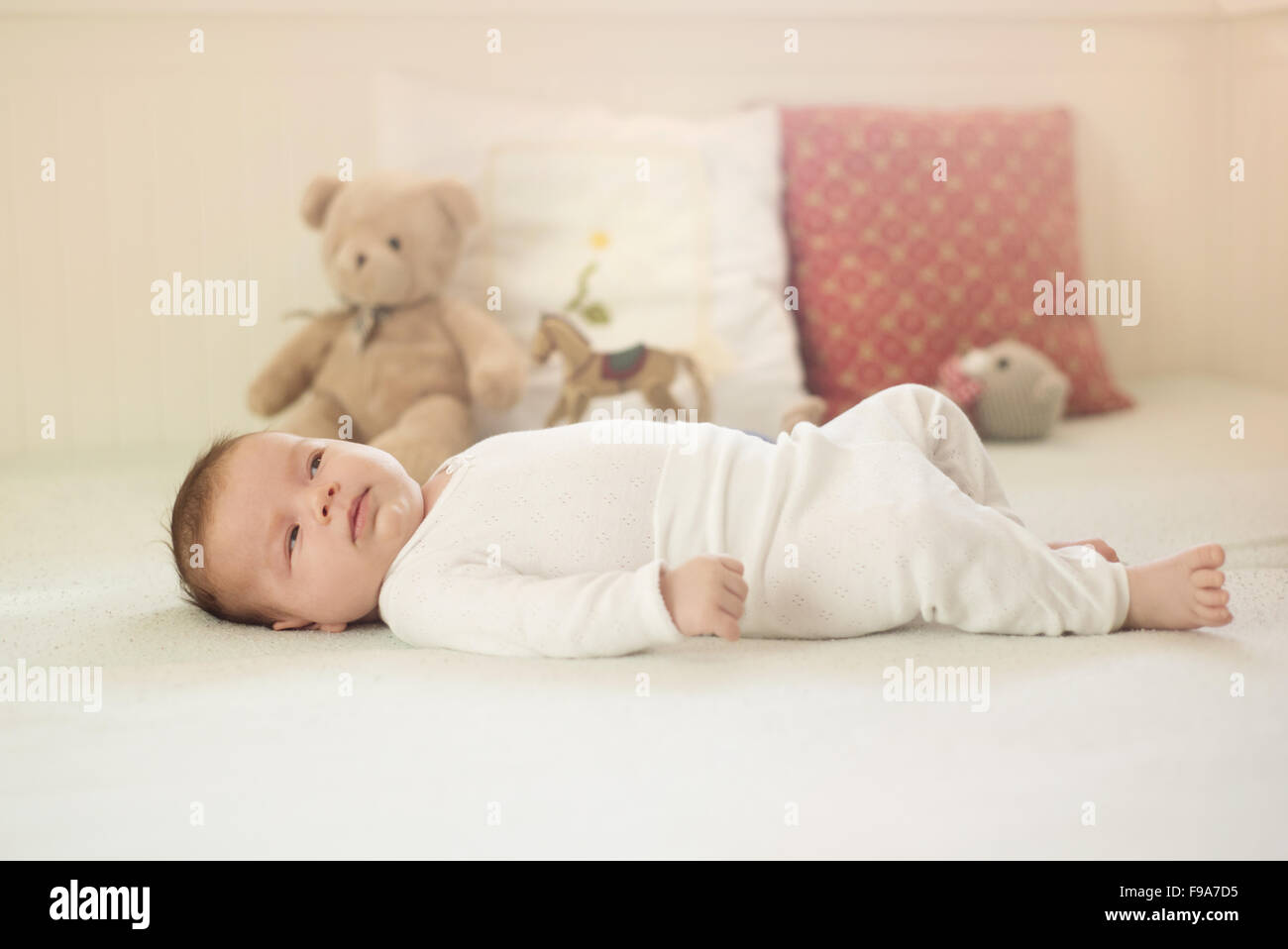 Newborn baby girl is laying down on the bed Stock Photo