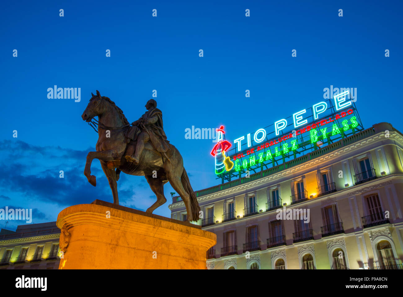 Tio Pepe neon sign on its new location and Carlos III statue, night view. Puerta del Sol, Madrid, Spain. Stock Photo