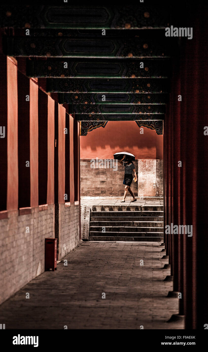 A tourist walking through a corridor in the Forbidden City Stock Photo