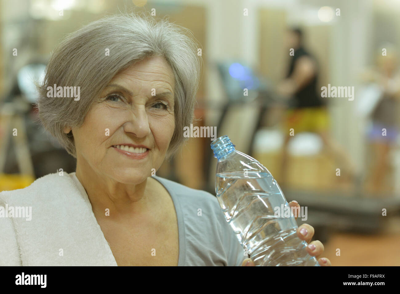 senior-woman-drinking-water-in-gym-stock-photo-alamy