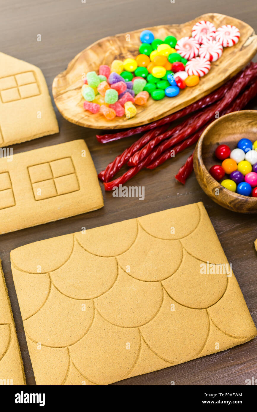 Decorating gingerbread house with royal icing and colorful candies ...