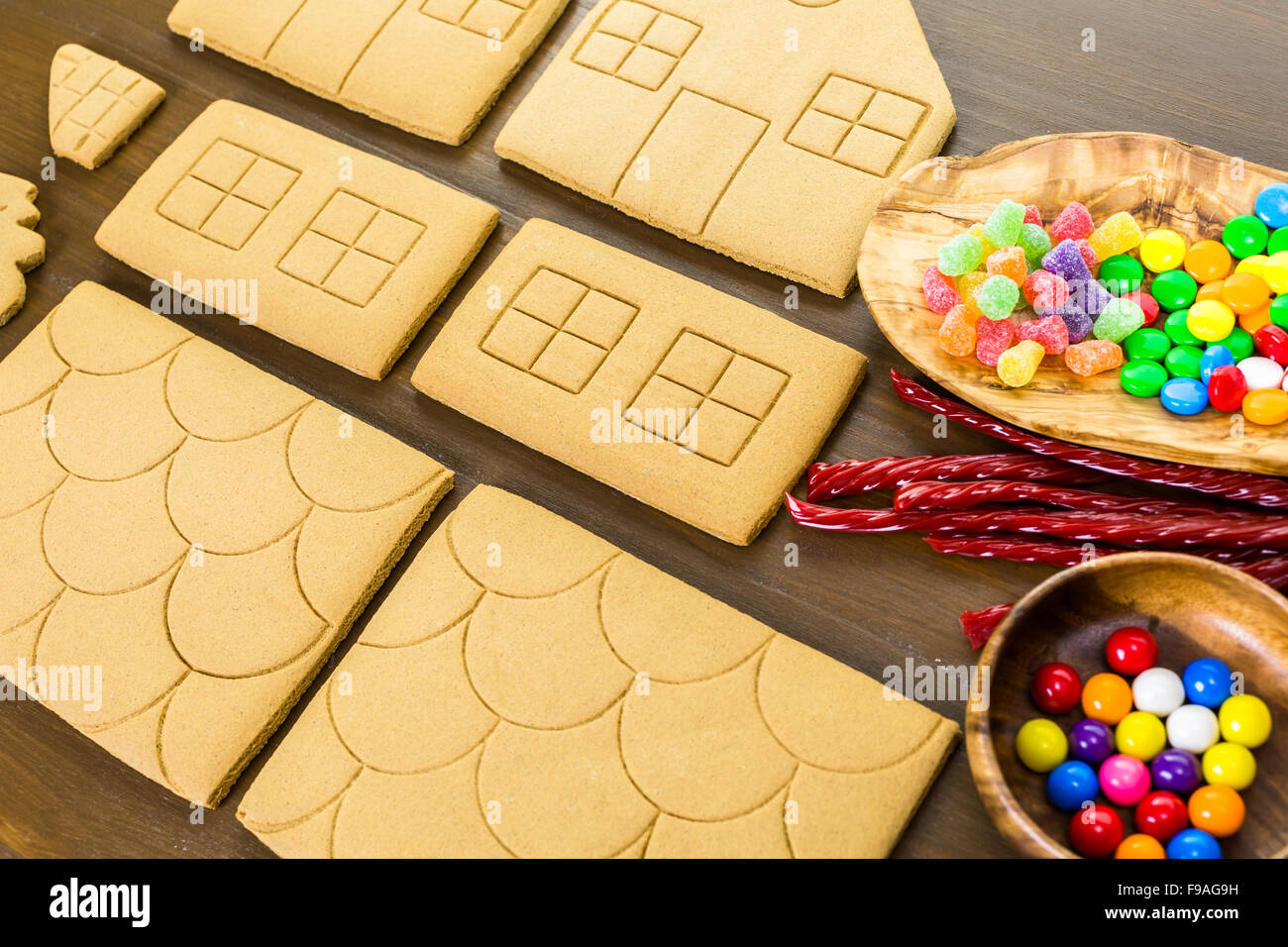 Decorating gingerbread house with royal icing and colorful candies ...