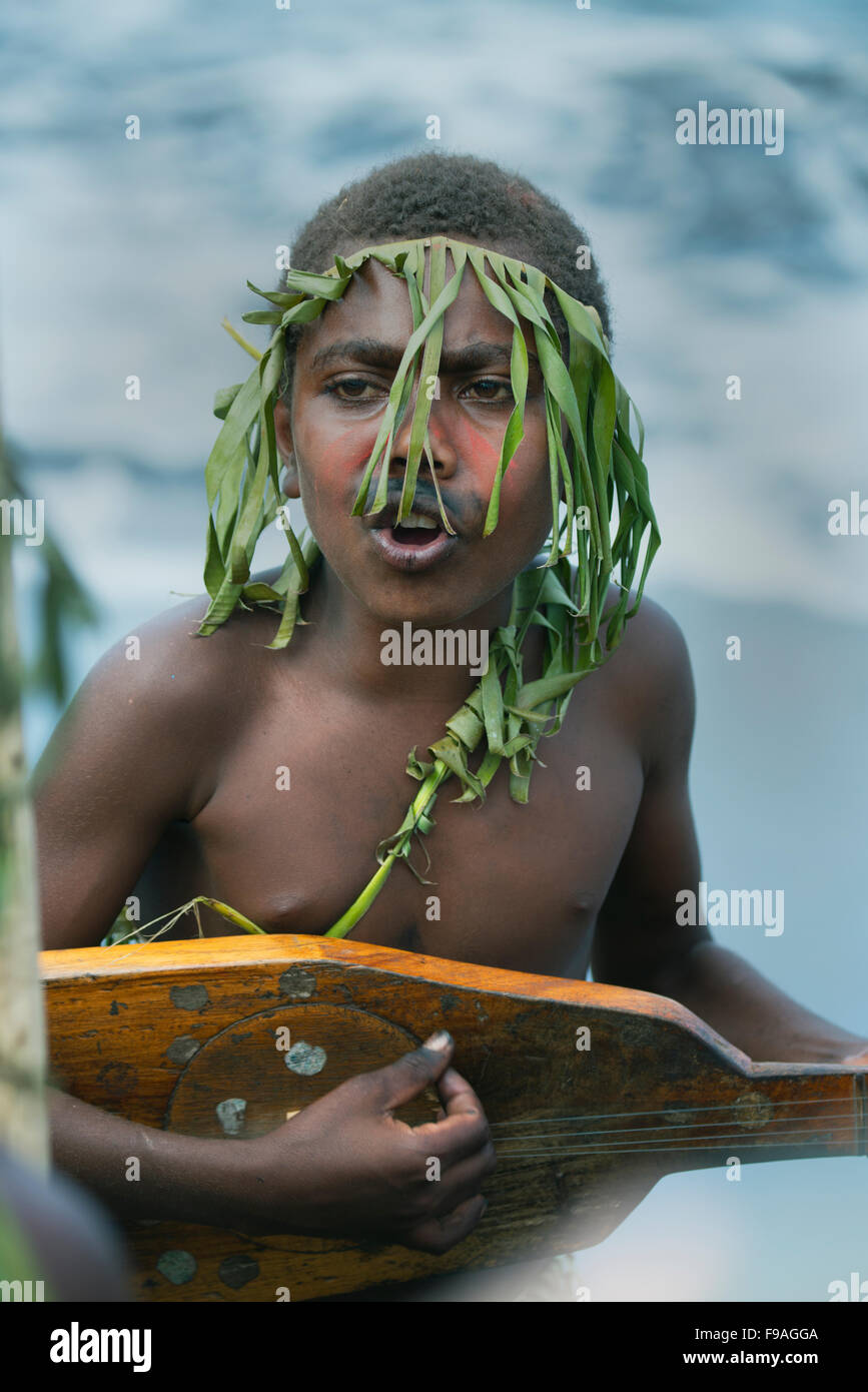 Young man in traditional attire, playing music with John Frum String Band, Tanna Island, Vanuatu, Melanesia Stock Photo