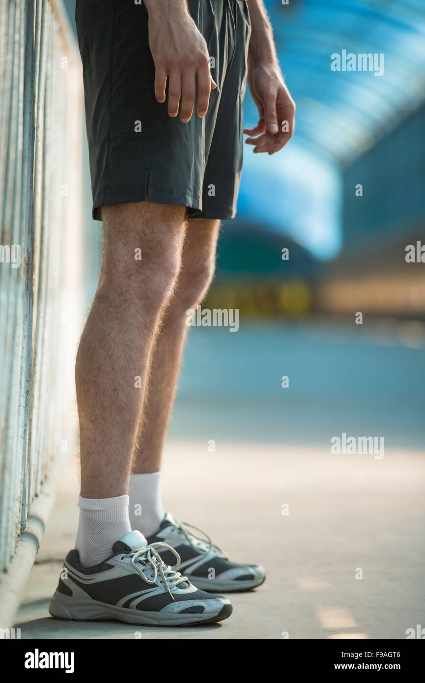 Unrecognizable man with athletic pair of legs going for jog or run during sunrise or sunset - healthy lifestyle concept Stock Photo