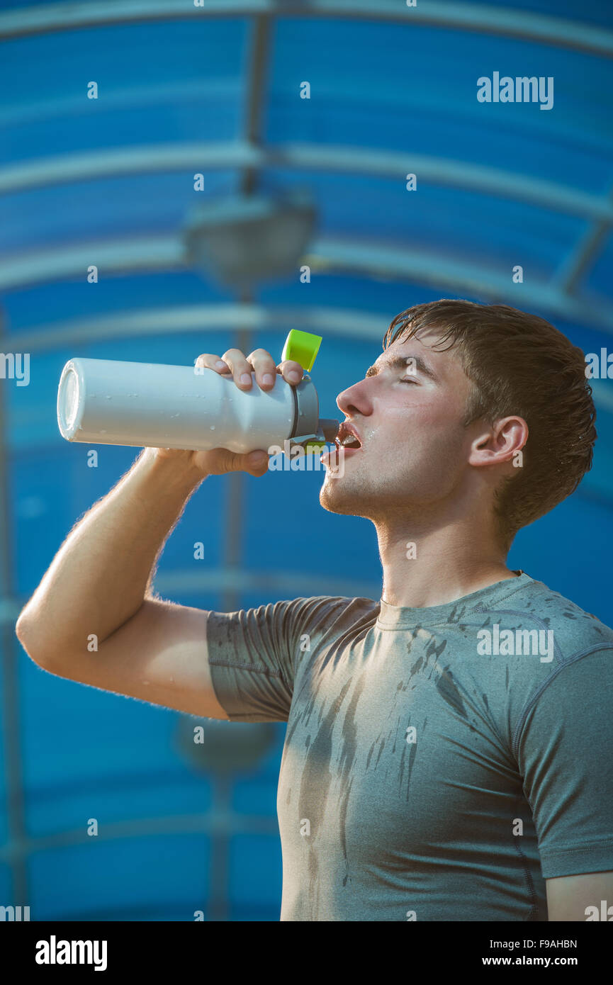 Athletic young man drinking water after hard training Stock Photo Alamy