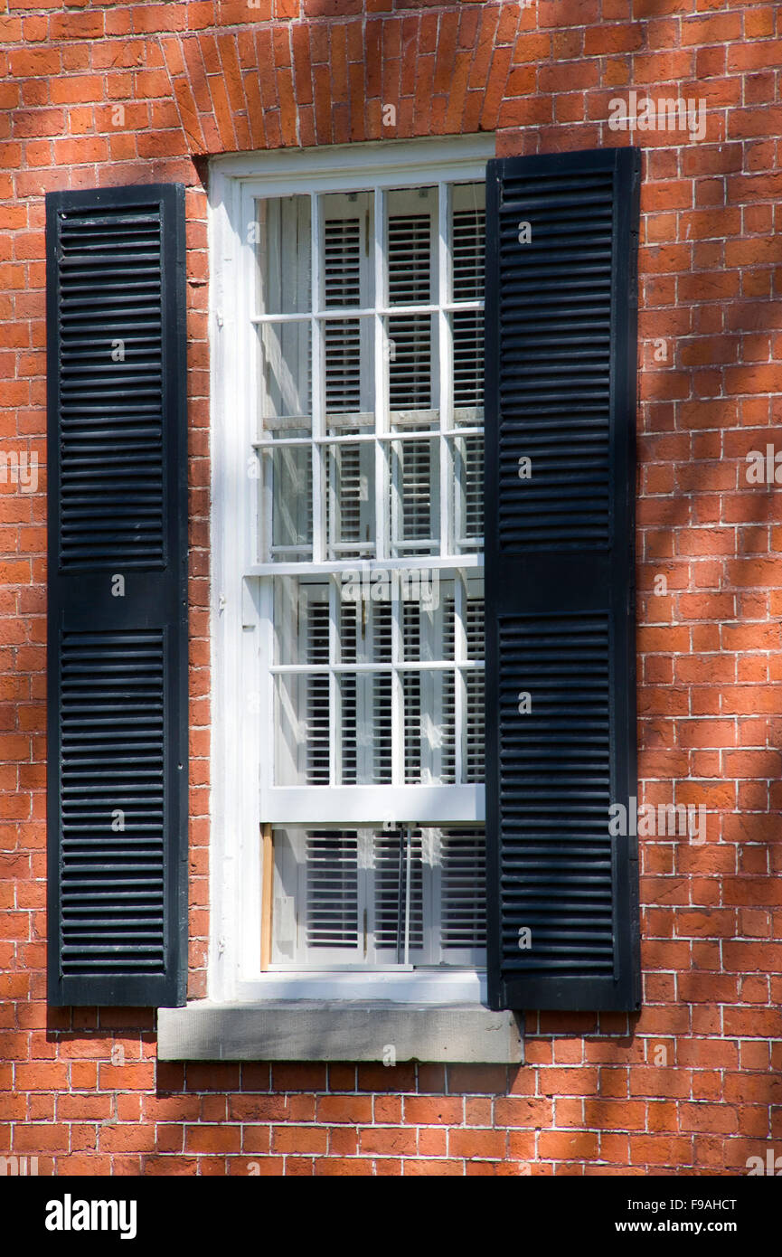 Traditional window with white frame, black shutters Stock Photo