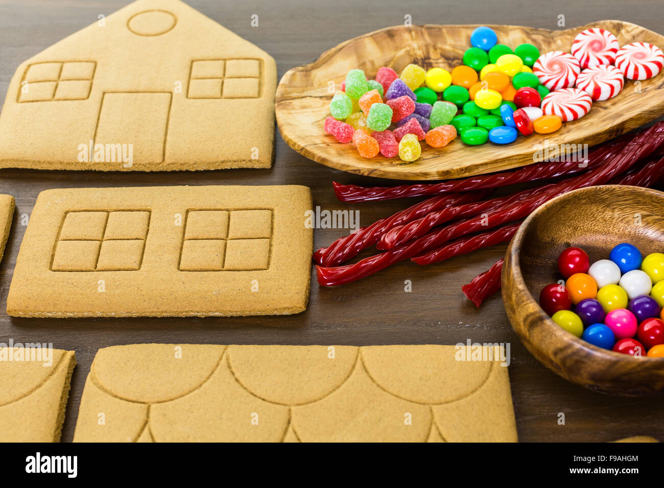 Decorating gingerbread house with royal icing and colorful candies ...