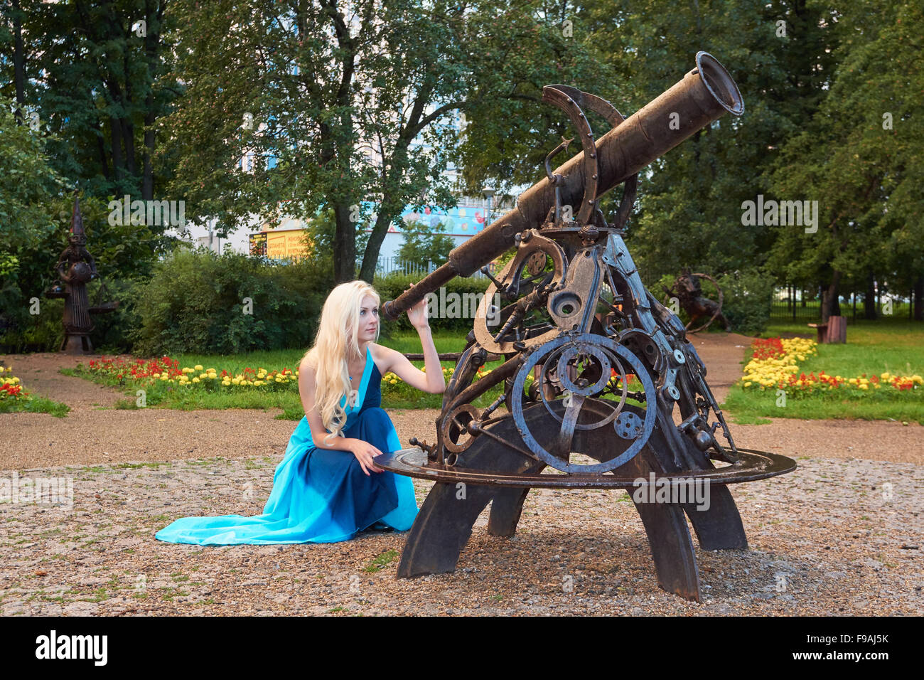 Attractive young girl looks through telescope in the park Stock Photo