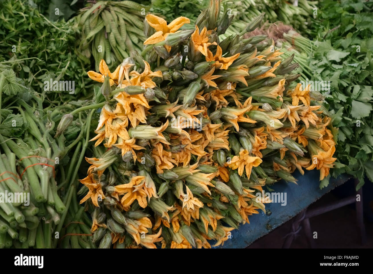 Harvested pumpkin flowers for sale on a stall in a Bangkok wet food market, Thailand Stock Photo