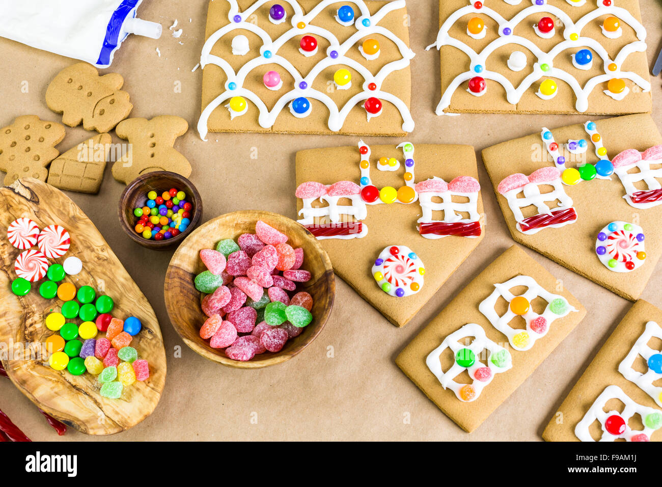 Decorating gingerbread house with royal icing and colorful candies ...