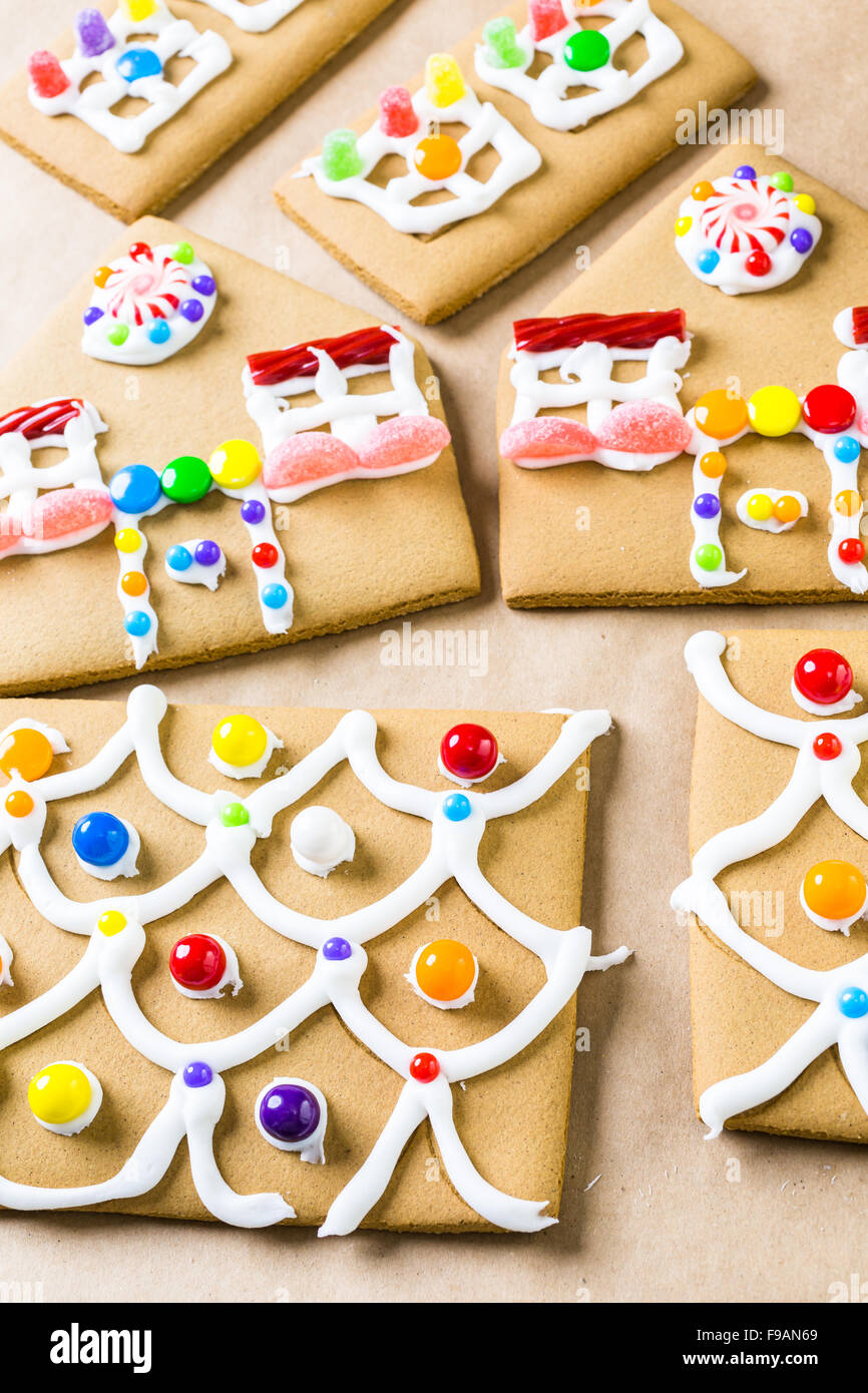 Decorating gingerbread house with royal icing and colorful candies ...