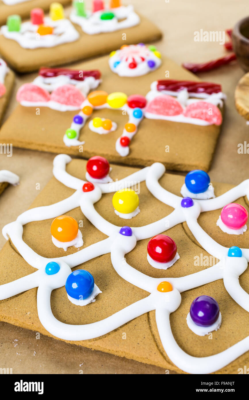 Decorating gingerbread house with royal icing and colorful candies ...