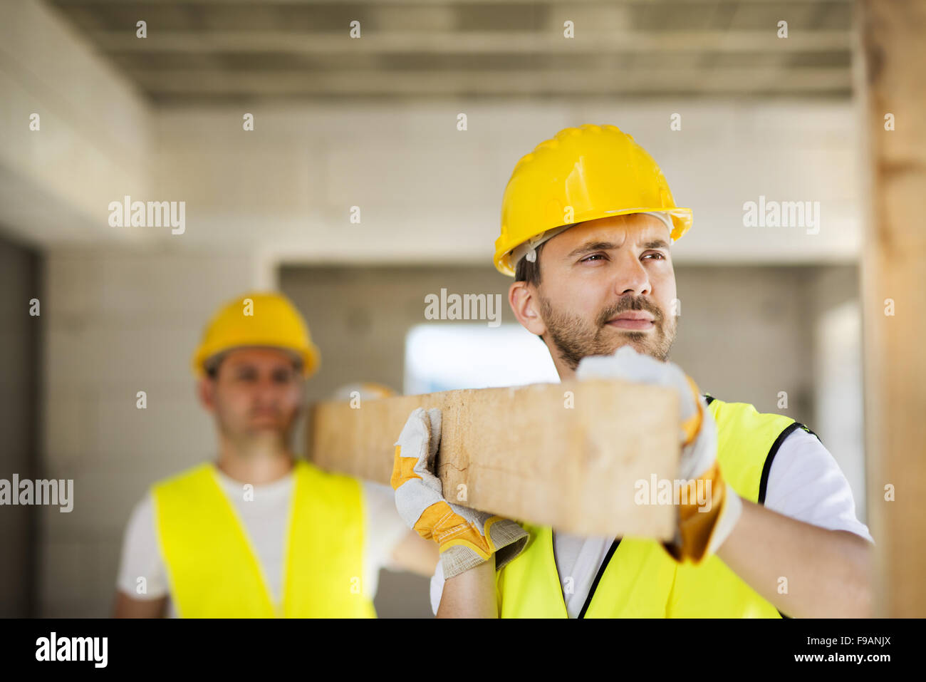 Construction workers collaborating on new house building Stock Photo