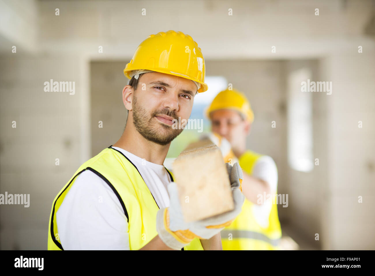 Construction workers collaborating on new house building Stock Photo