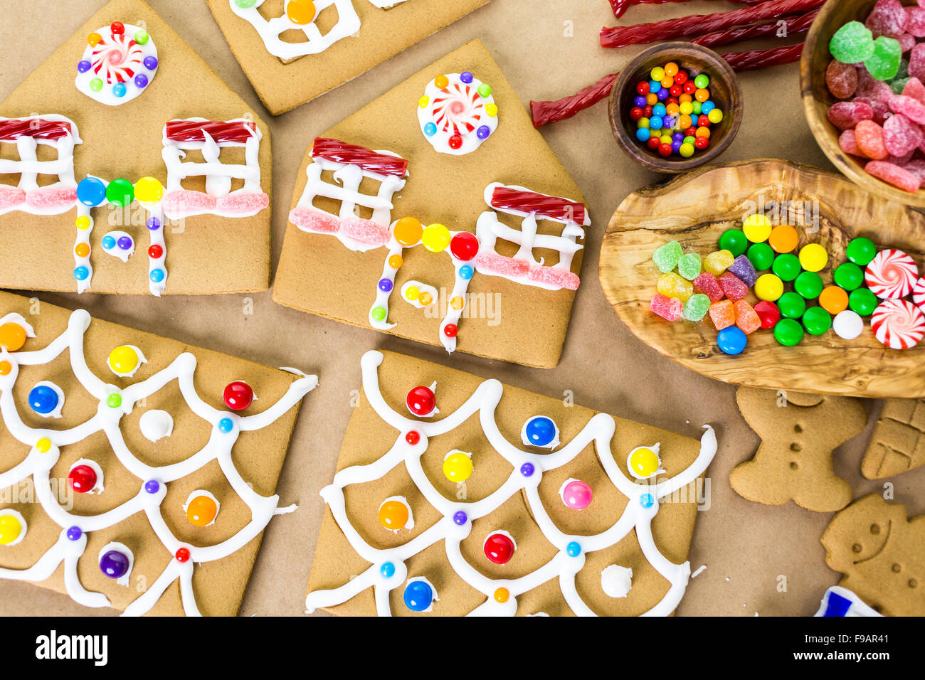 Decorating gingerbread house with royal icing and colorful candies ...