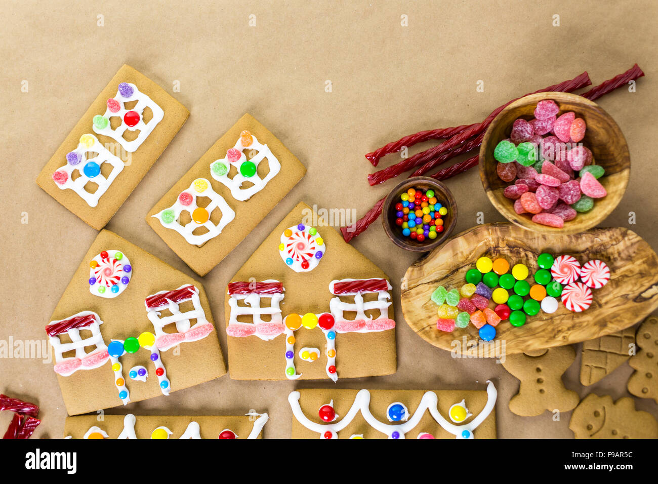 Decorating gingerbread house with royal icing and colorful candies ...