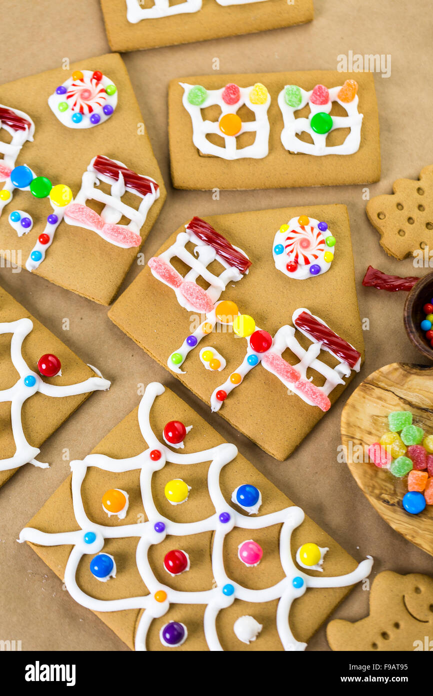 Decorating gingerbread house with royal icing and colorful candies ...
