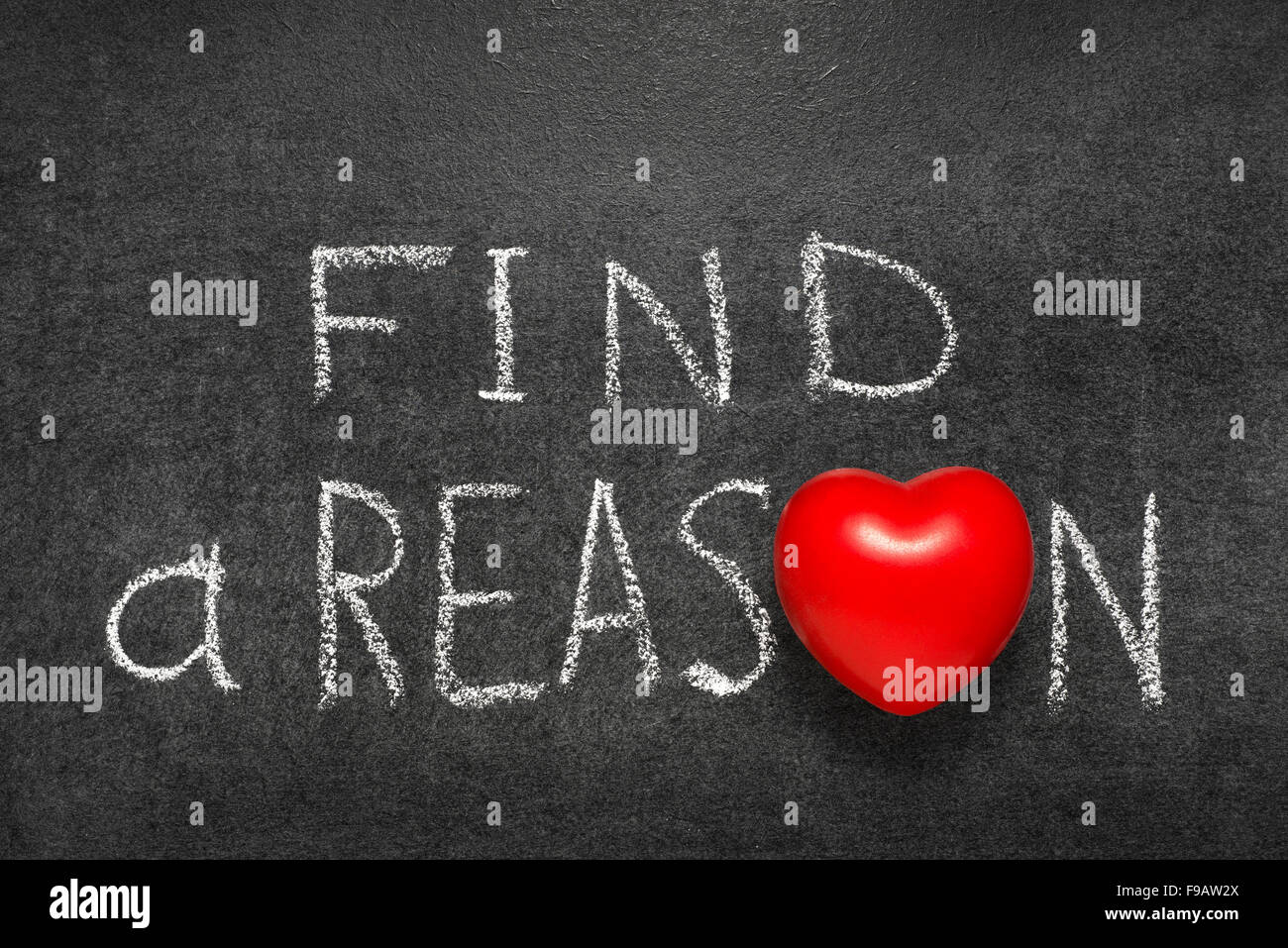 find a reason phrase handwritten on blackboard with heart symbol instead O Stock Photo