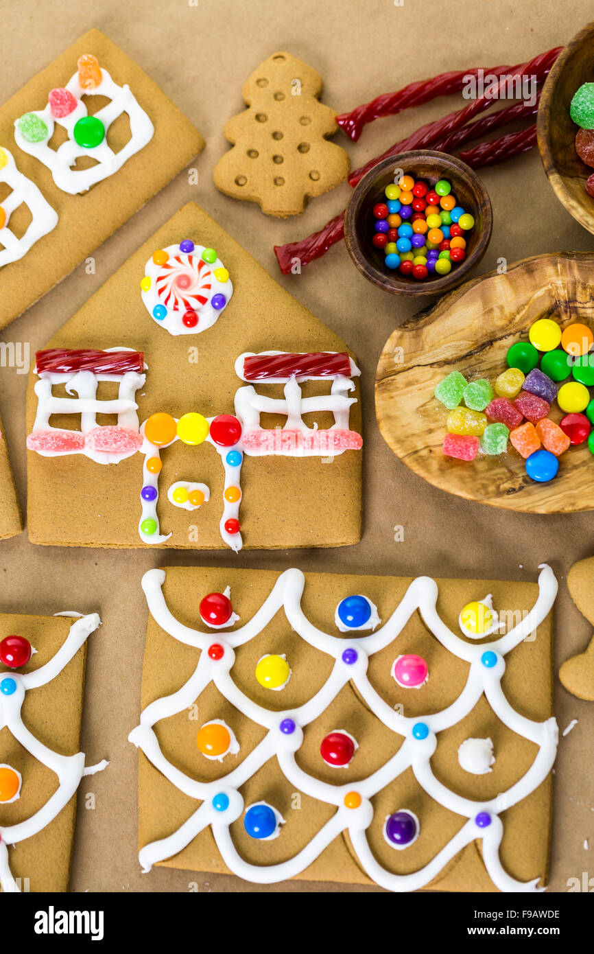 Decorating gingerbread house with royal icing and colorful candies ...