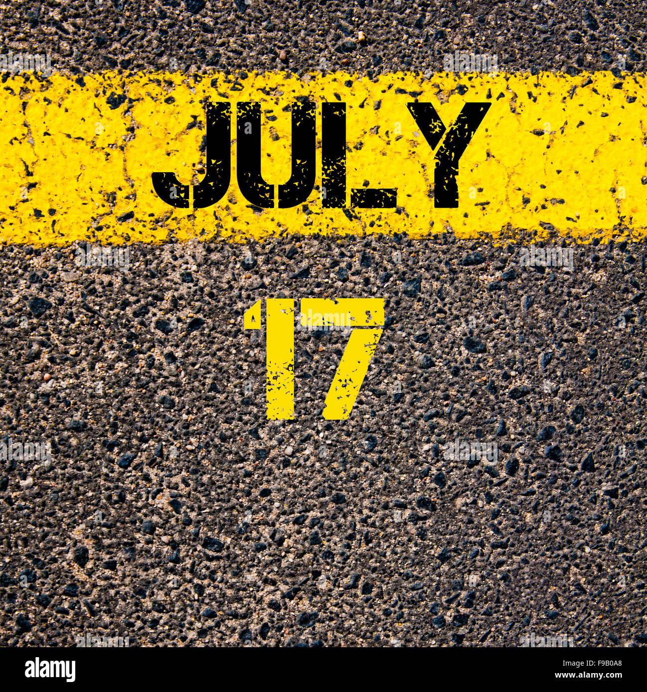 17 July calendar day written over road marking yellow paint line Stock