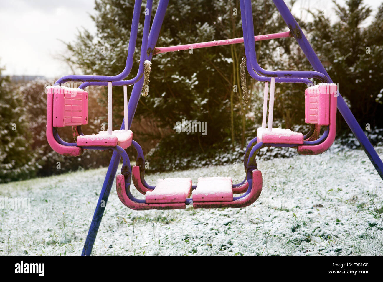 dirty swing on playground in the snow Stock Photo Alamy