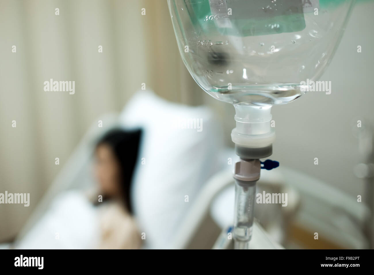 Saline IV drip bottle provided to the patient girl on the background Stock Photo