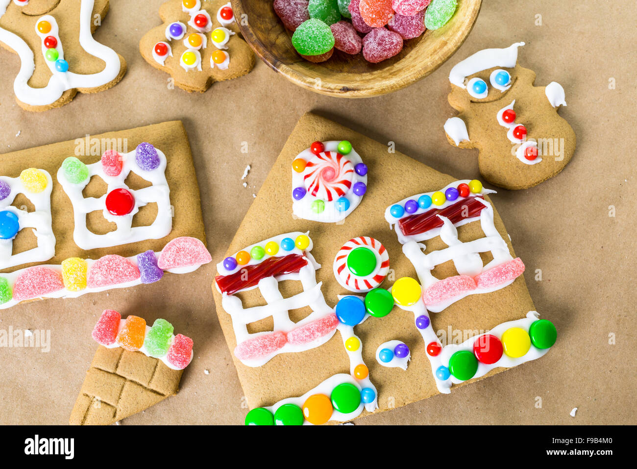 Decorating gingerbread house with royal icing and colorful candies ...