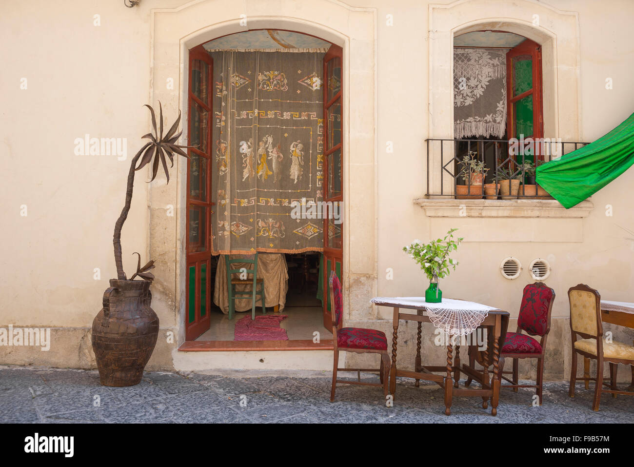 Restaurant Sicily, dining table and chairs placed outside Trattoria La Foglia in the old town area of Ortigia, Syracuse,Sicily. Stock Photo