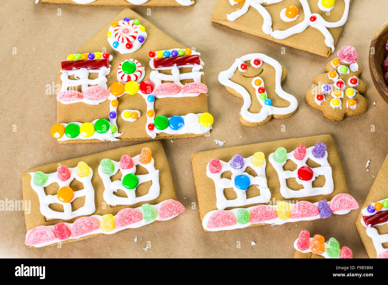 Decorating gingerbread house with royal icing and colorful candies ...