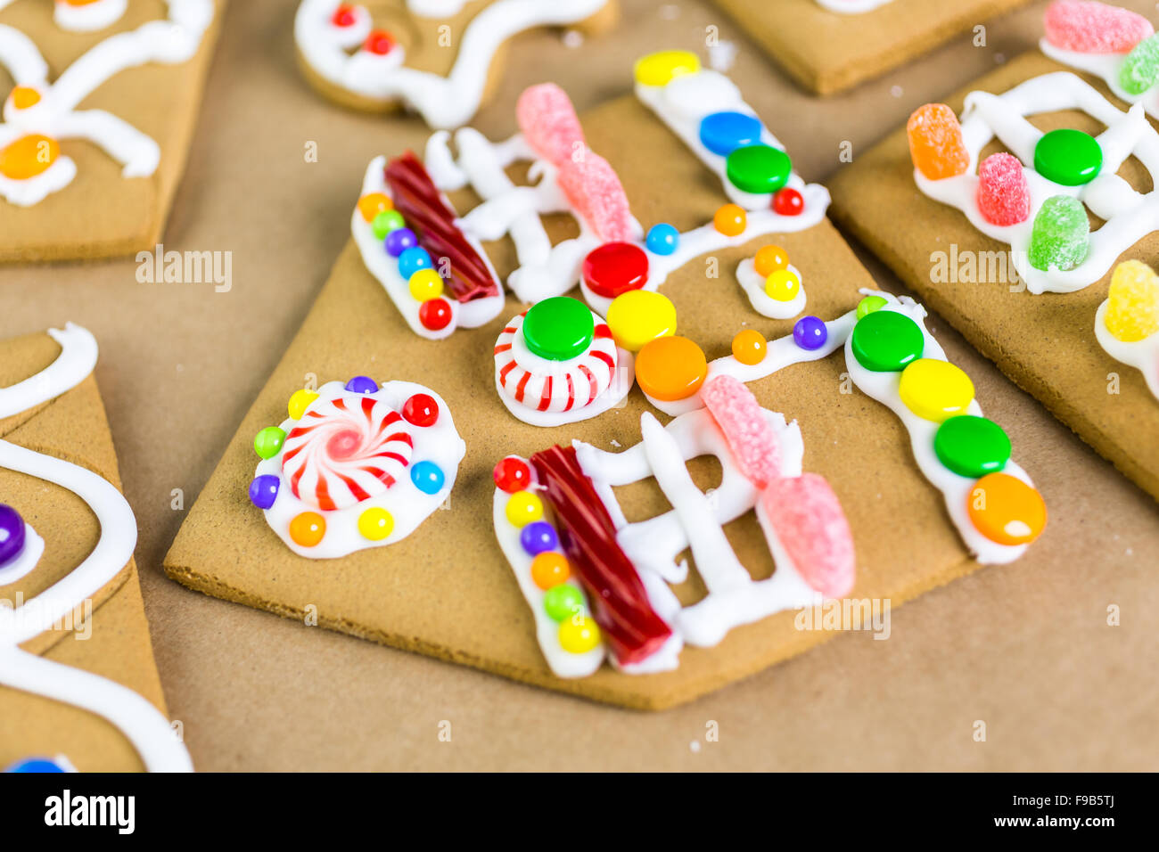 Decorating gingerbread house with royal icing and colorful candies ...