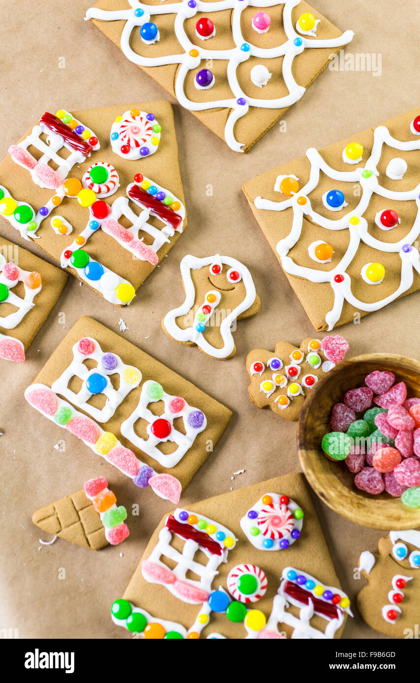 Decorating gingerbread house with royal icing and colorful candies ...