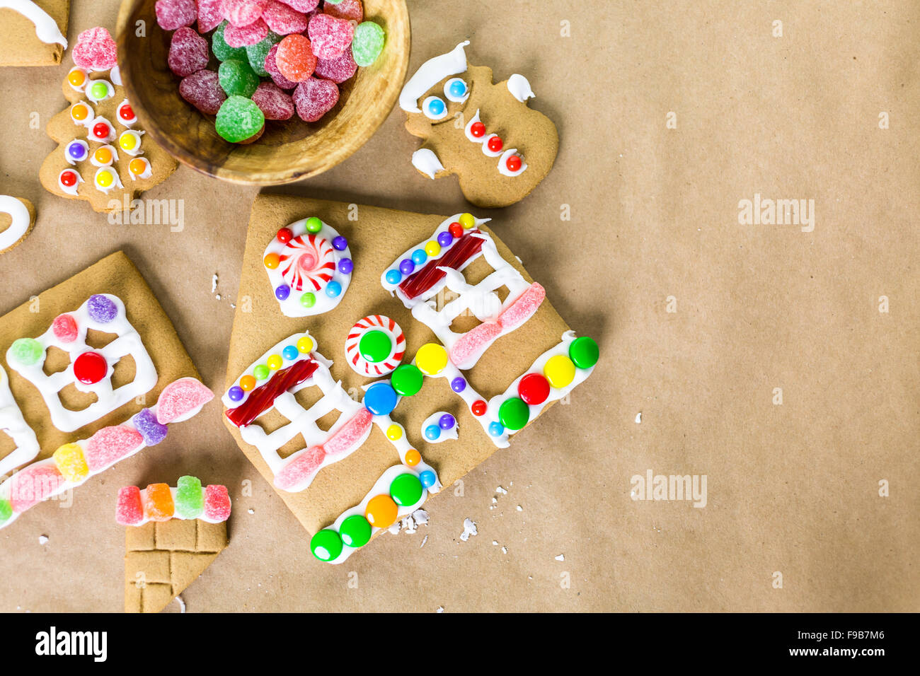 Decorating gingerbread house with royal icing and colorful candies ...
