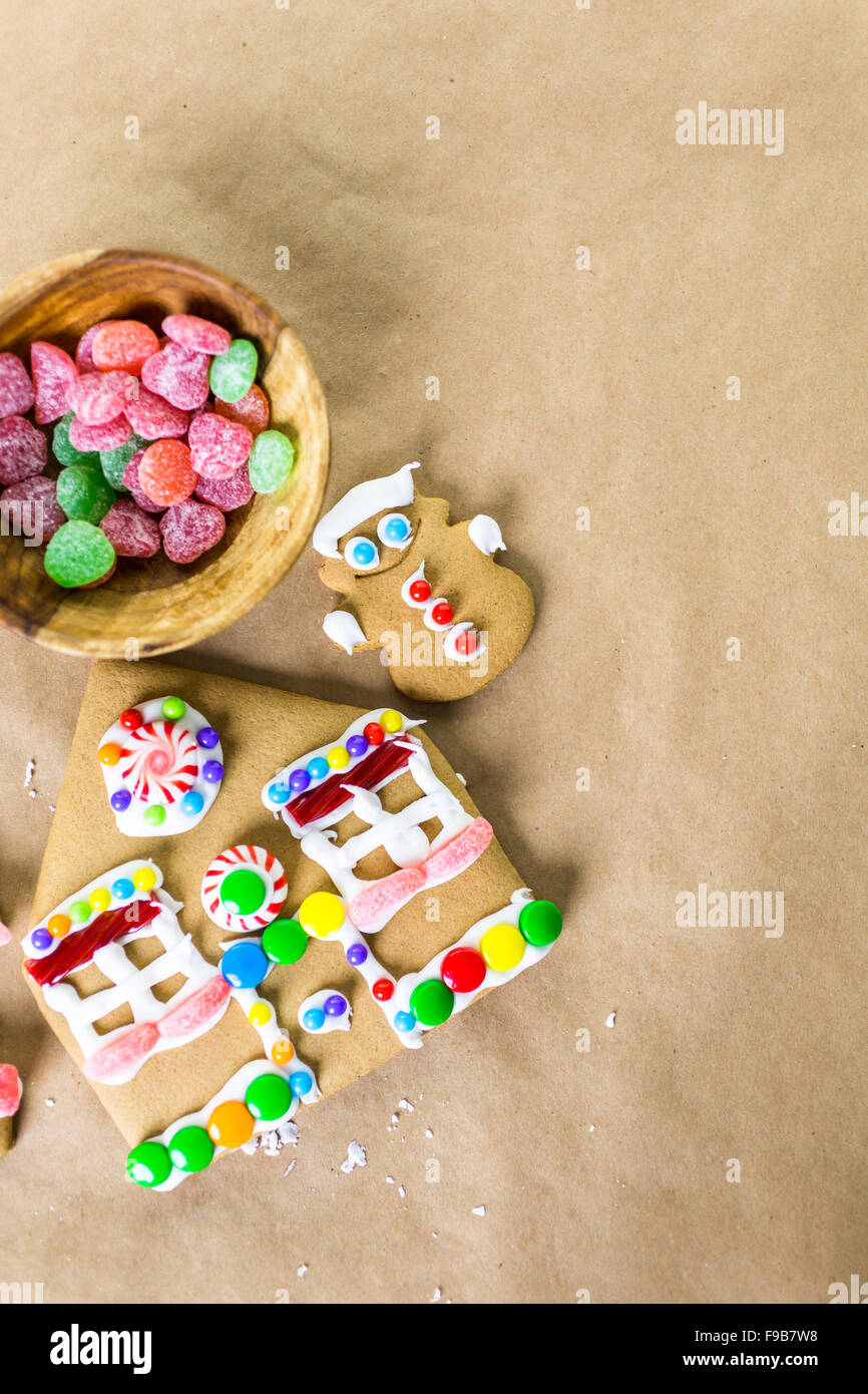Decorating gingerbread house with royal icing and colorful candies ...